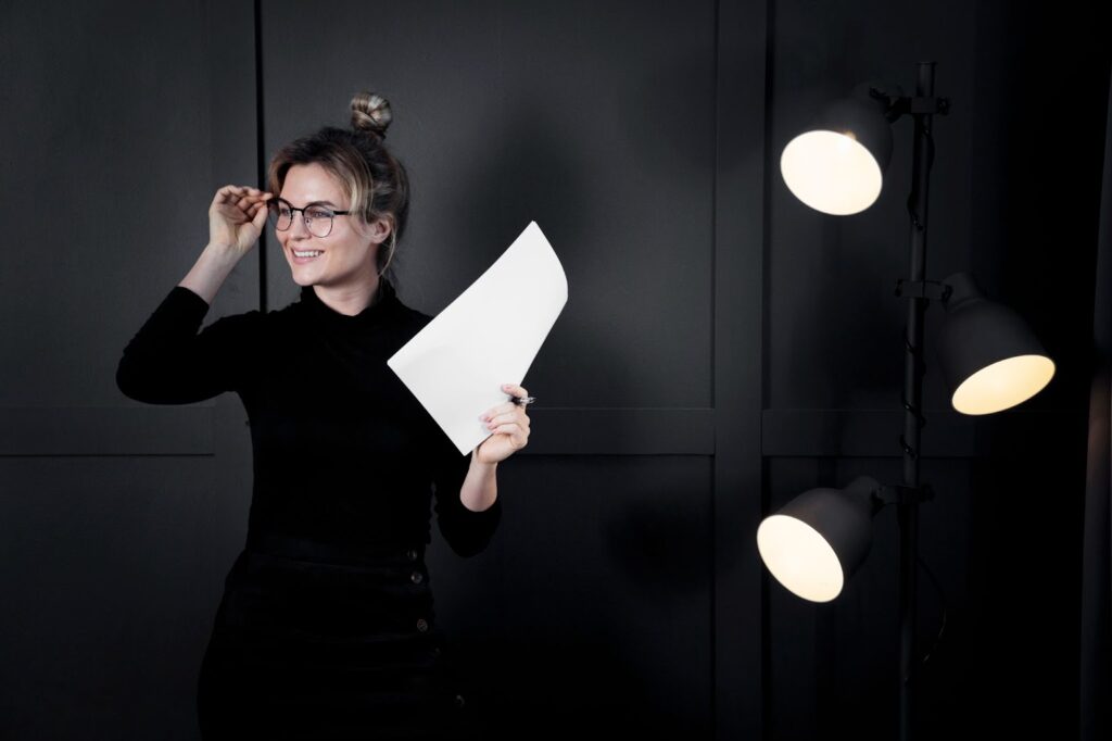 Confident woman with glasses looking away and holding paper