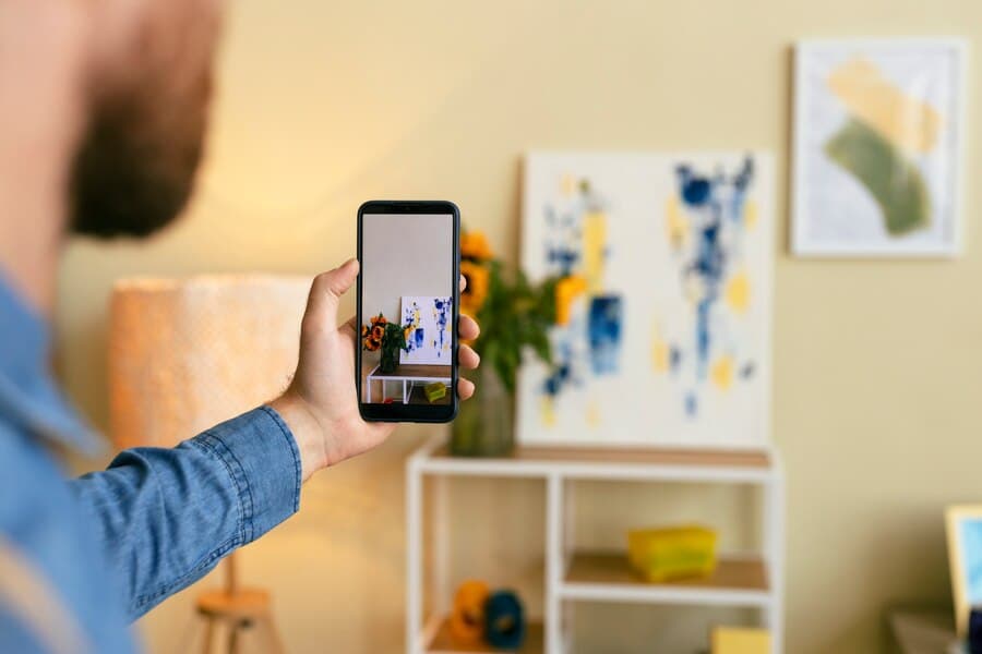 man taking photo of painting