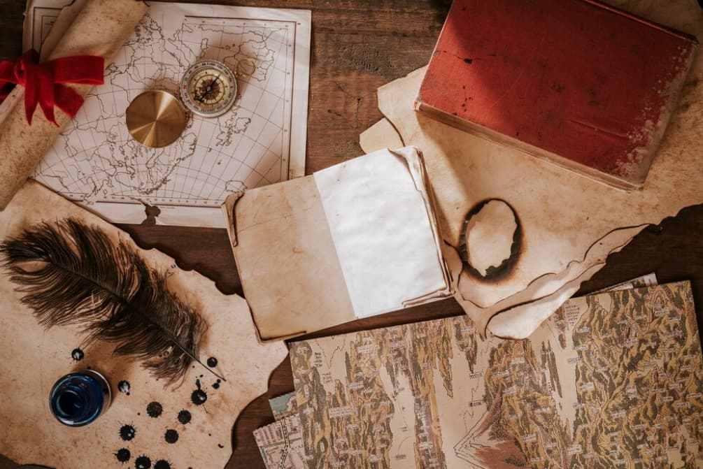 Vintage maps and navigation tools on a wooden desk