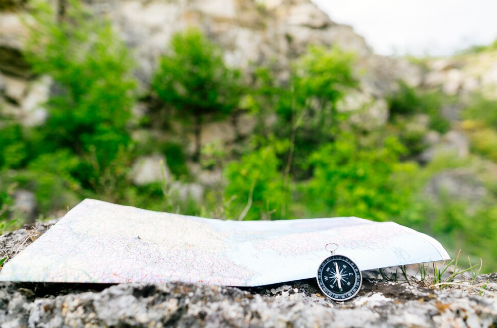 Compass on a map in a natural, rocky landscape