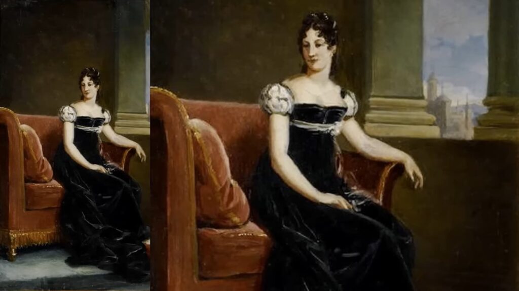 An elegant woman seated in a red chair, wearing a black dress
