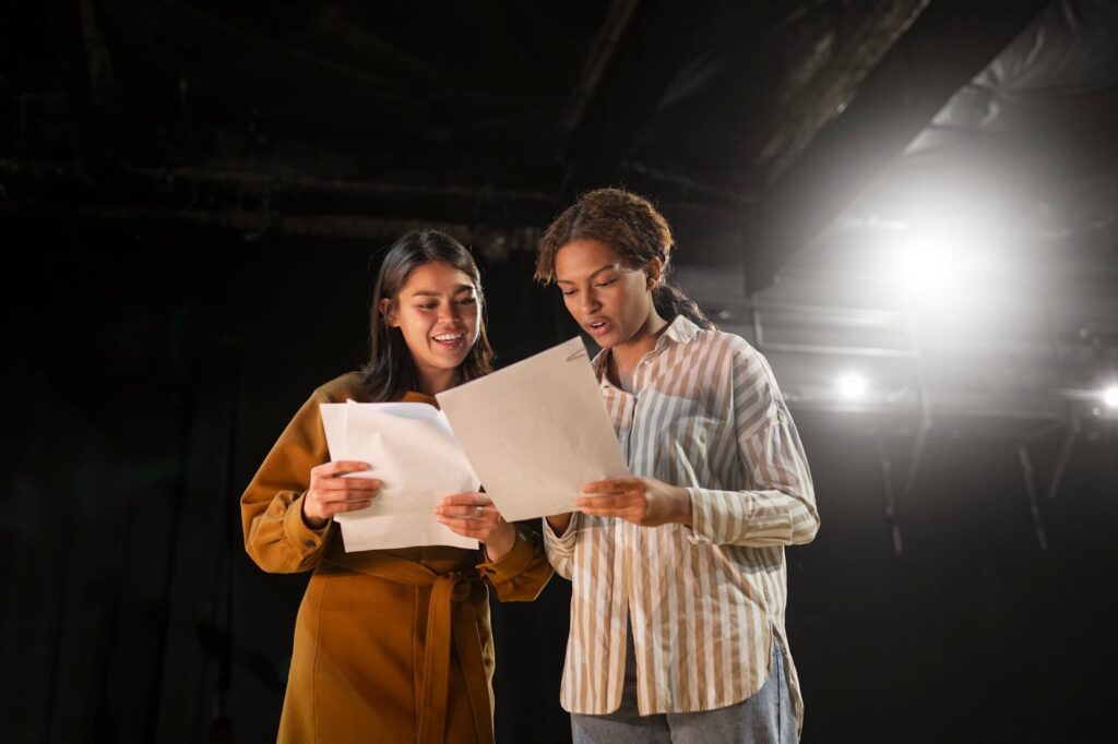 Girls rehearsing a script on stage