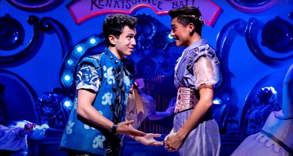 A girl and a guy in bright suits perform on stage